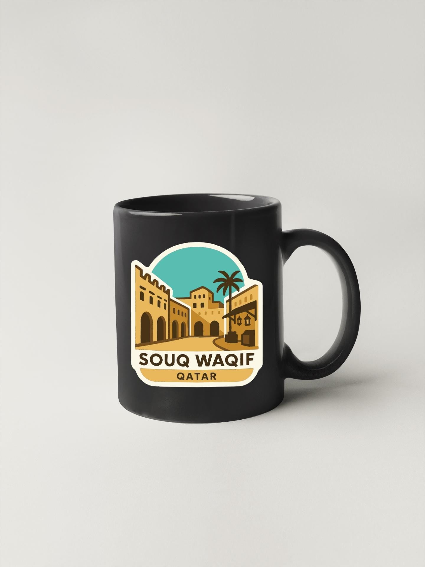 A black coffee mug with a graphic design depicting a cityscape and palm trees, along with the text "SOUQ WAIF QATAR".