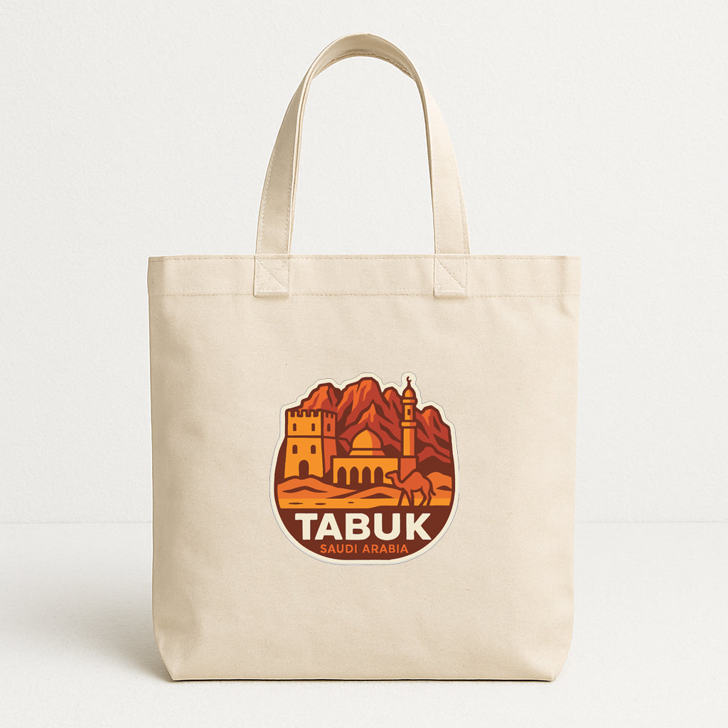 A beige tote bag with a circular graphic on it, depicting a desert landscape with a castle and a camel.