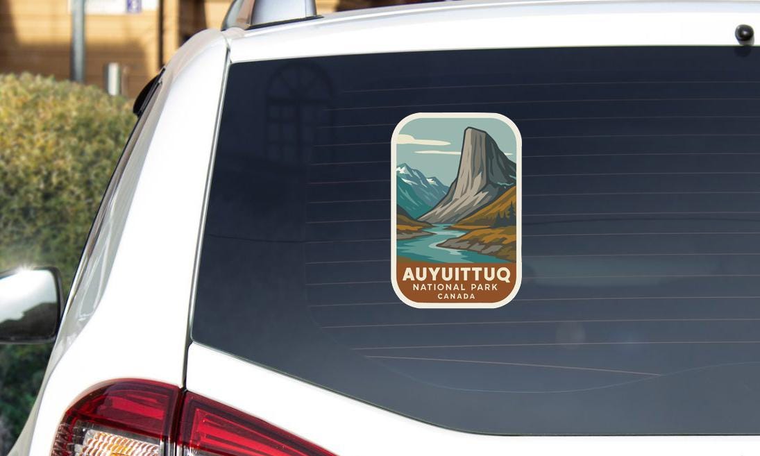 a sticker on the rear window of a car, depicting a scenic mountain landscape with a river.