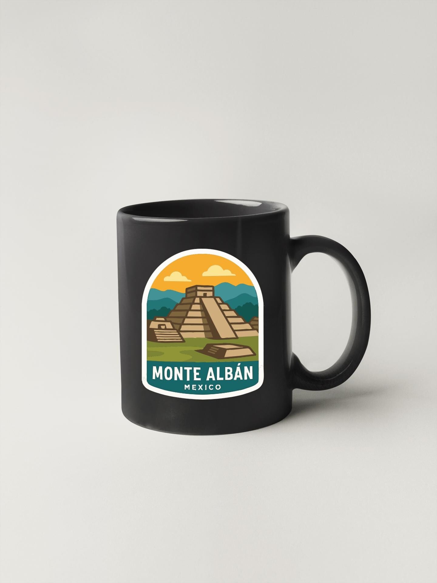 A black coffee mug with a graphic design depicting the Mayan pyramid of Monte Albán, a famous landmark in Mexico.