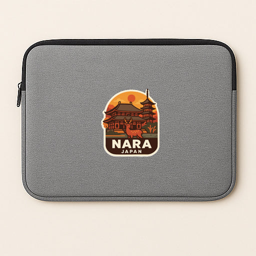 A gray laptop sleeve with a sticker depicting a temple and a deer, along with the text "NARA JAPAN".