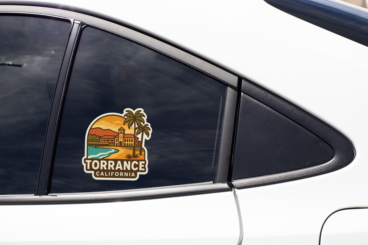A car window with a sticker depicting a beach scene and palm trees, along with the text "TORRANCE CALIFORNIA".