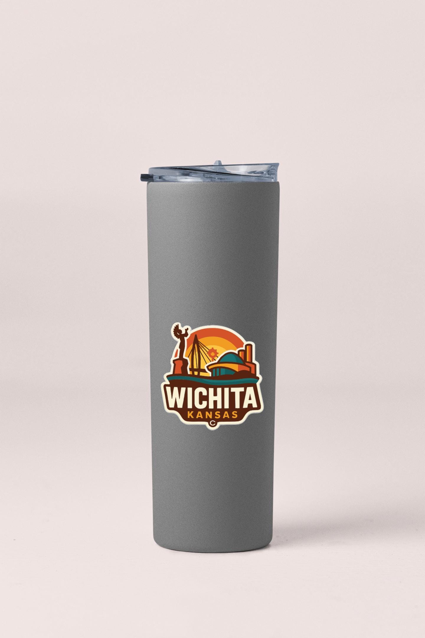 A gray insulated tumbler with a lid and a sticker featuring the state of Kansas.