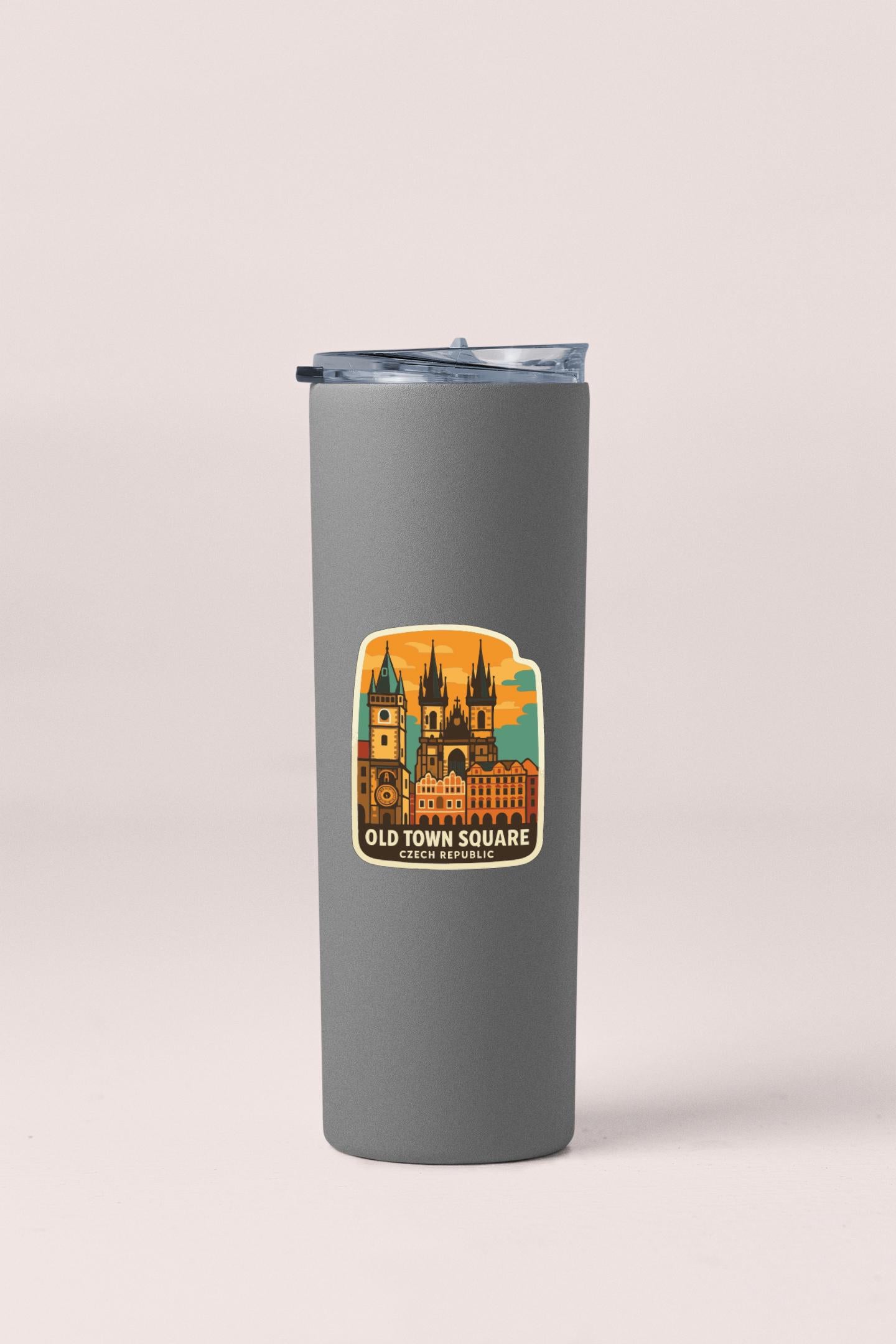 A gray insulated tumbler with a sticker depicting the Old Town Square in Prague, Czech Republic.