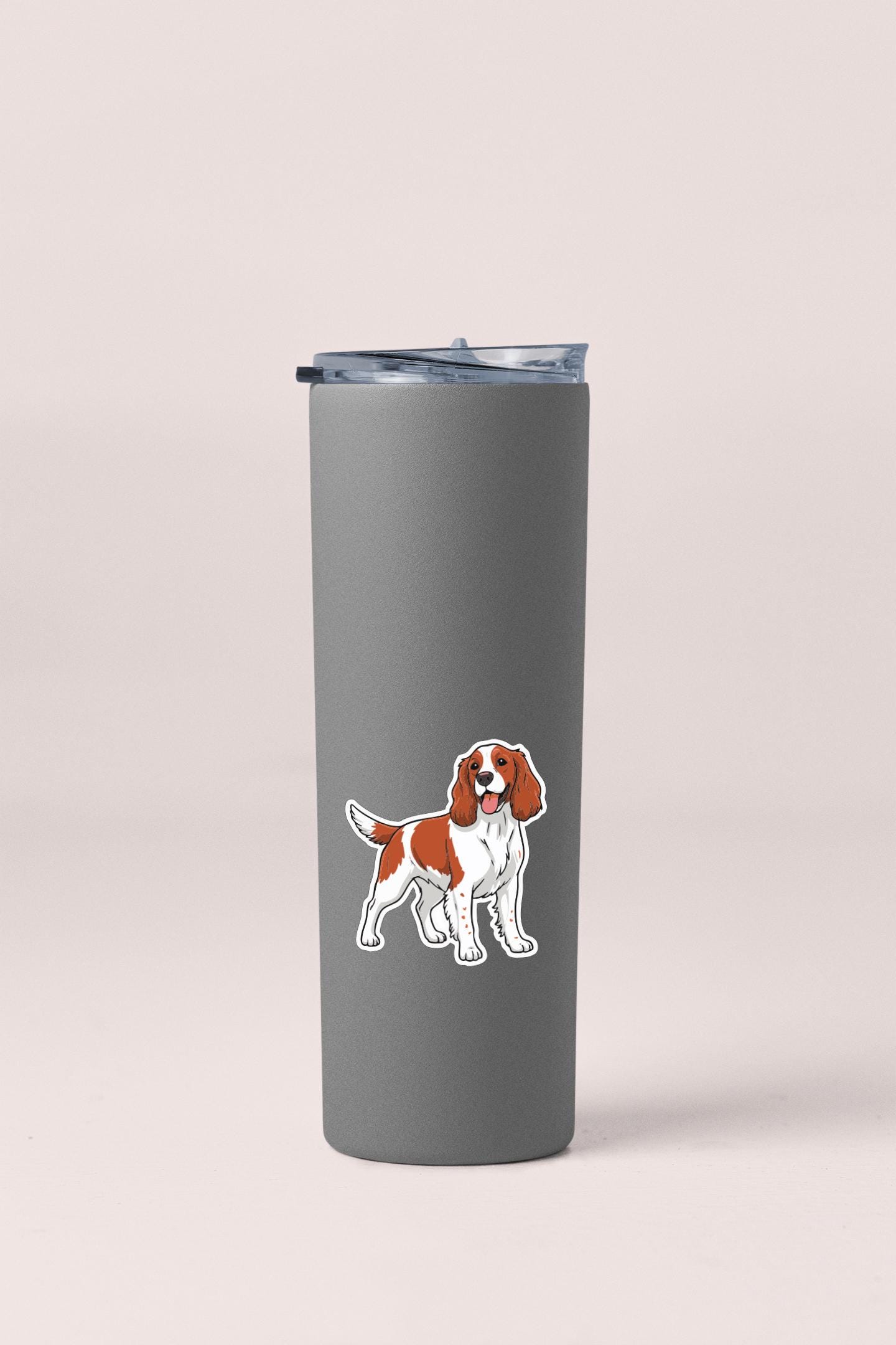 A gray insulated tumbler with a sticker of a dog on it.