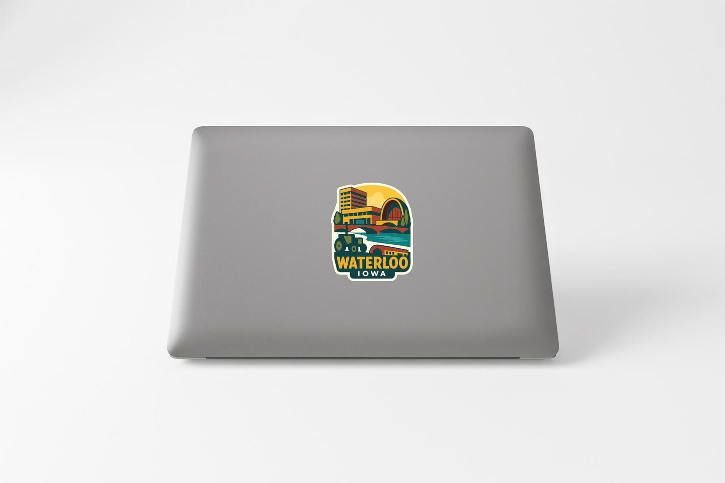 A sticker on the back of a laptop, depicting a colorful illustration of a cityscape with the text "WATERLOO IOWA".