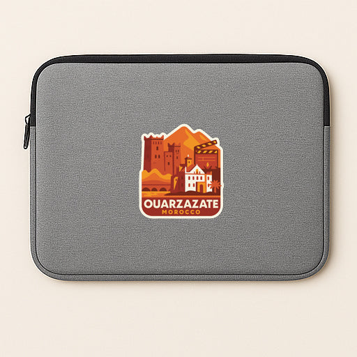 a gray laptop sleeve with a sticker depicting a cityscape and the text "QUARRAZATE MÜROCCO".