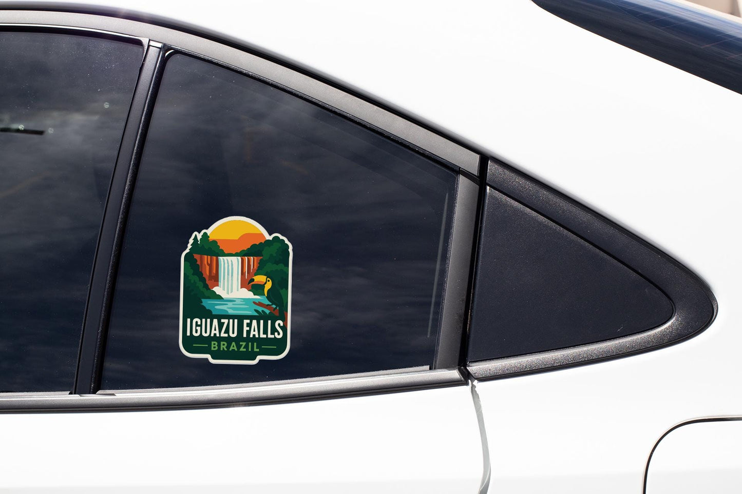 A sticker on the side of a car window, depicting a scenic landscape with a waterfall and a sunset.