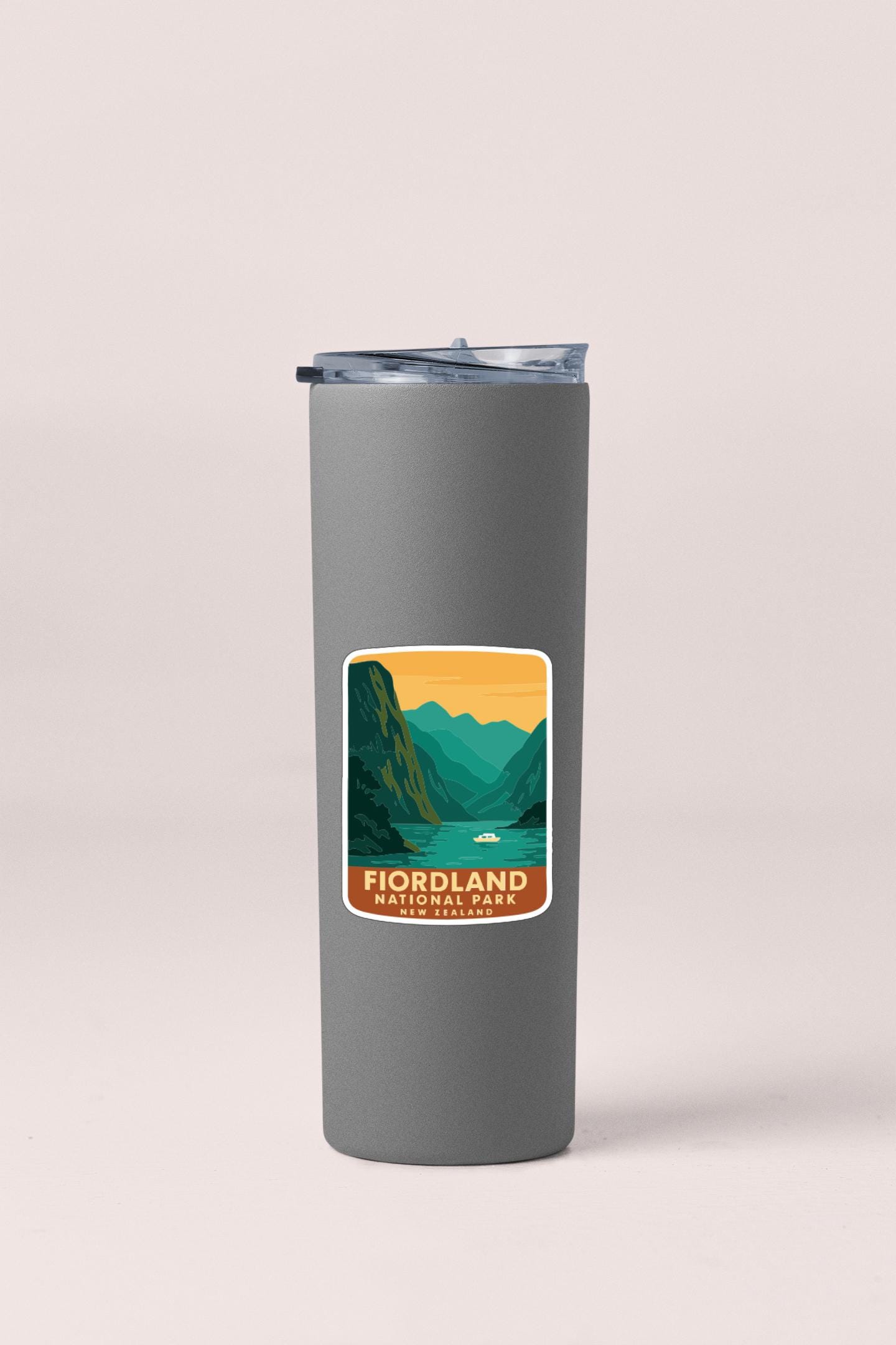 A gray insulated tumbler with a label that says "FIORLDLAND NATIONAL PARK NEW ZEALAND".