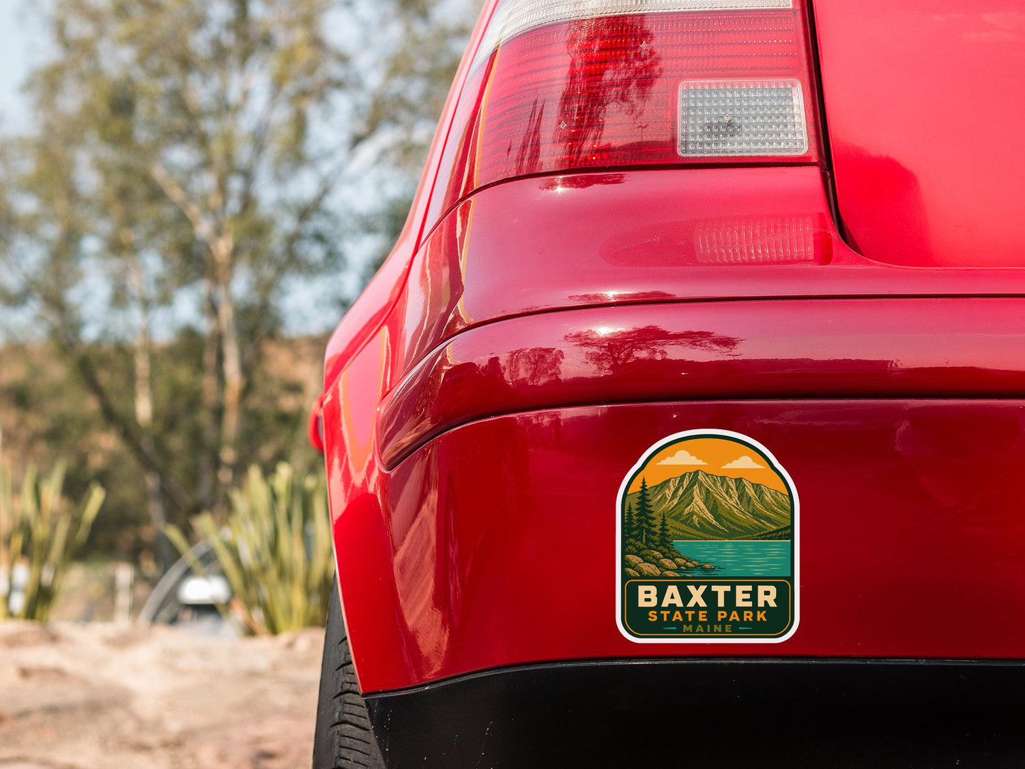 the rear end of a red car with a sticker on the bumper that says " Baxter State Park".