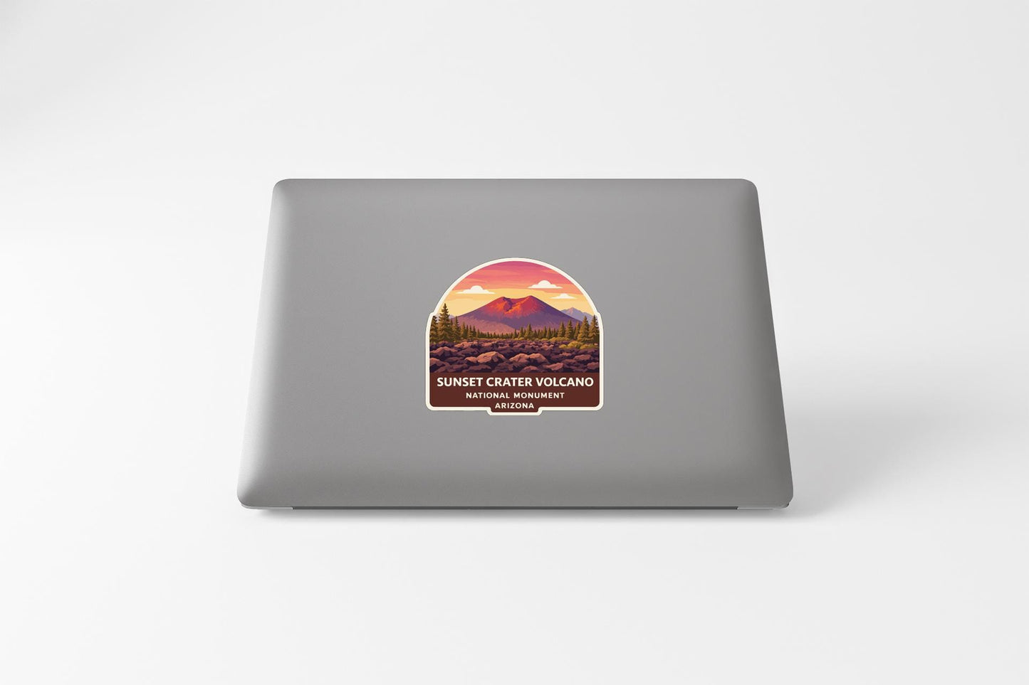 a sticker with a mountain landscape and a sunset over the mountains, representing the Sunset Crater Volcano National Monument.