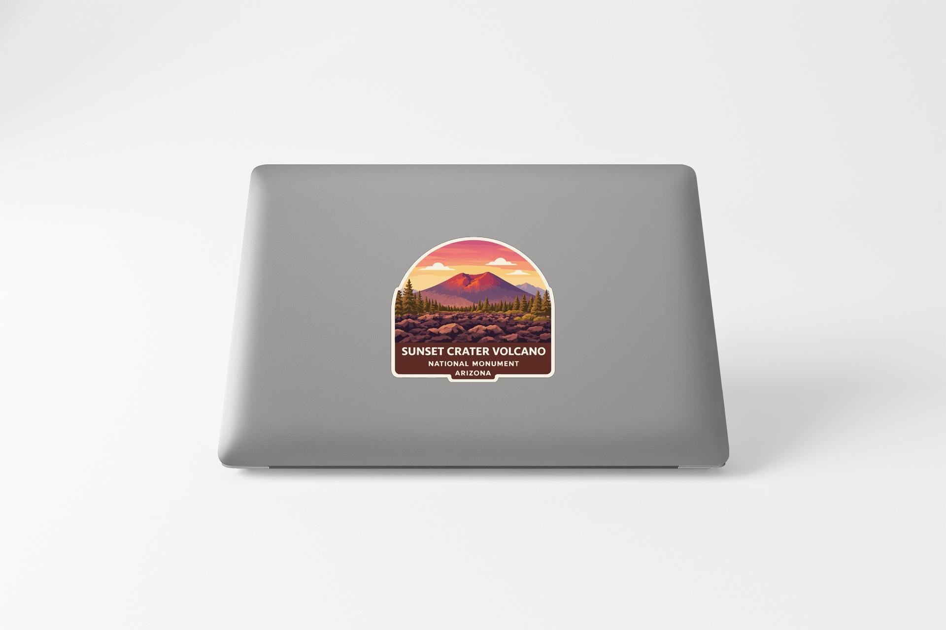 a sticker with a mountain landscape and a sunset over the mountains, representing the Sunset Crater Volcano National Monument.