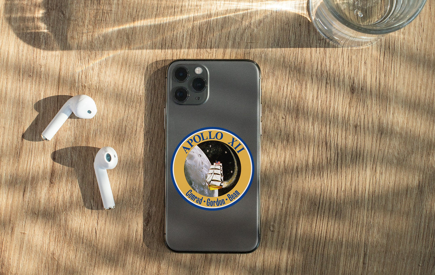 a cell phone with a sticker on it next to ear buds