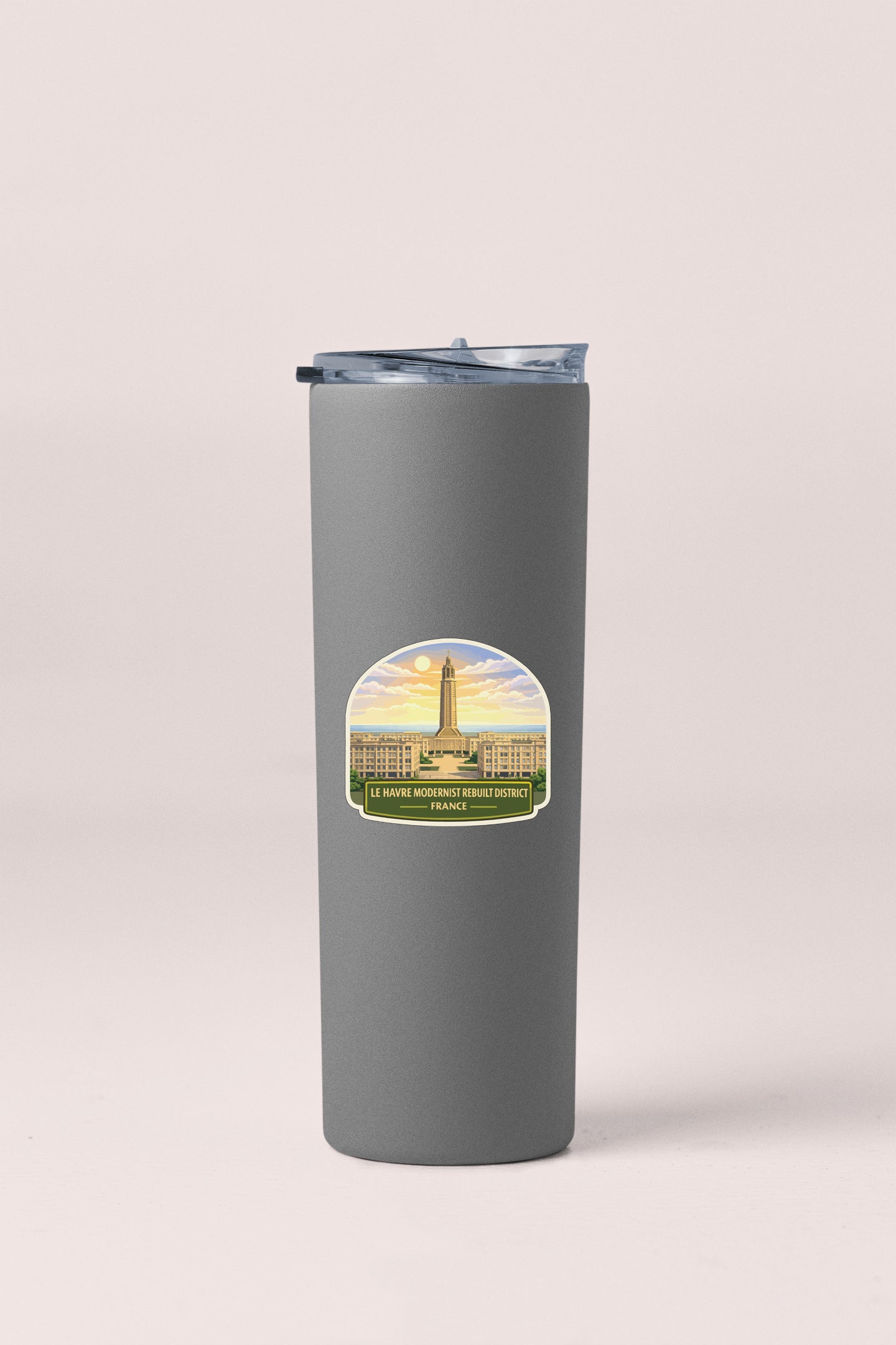 A gray insulated tumbler with a sticker depicting a building and a sunset.