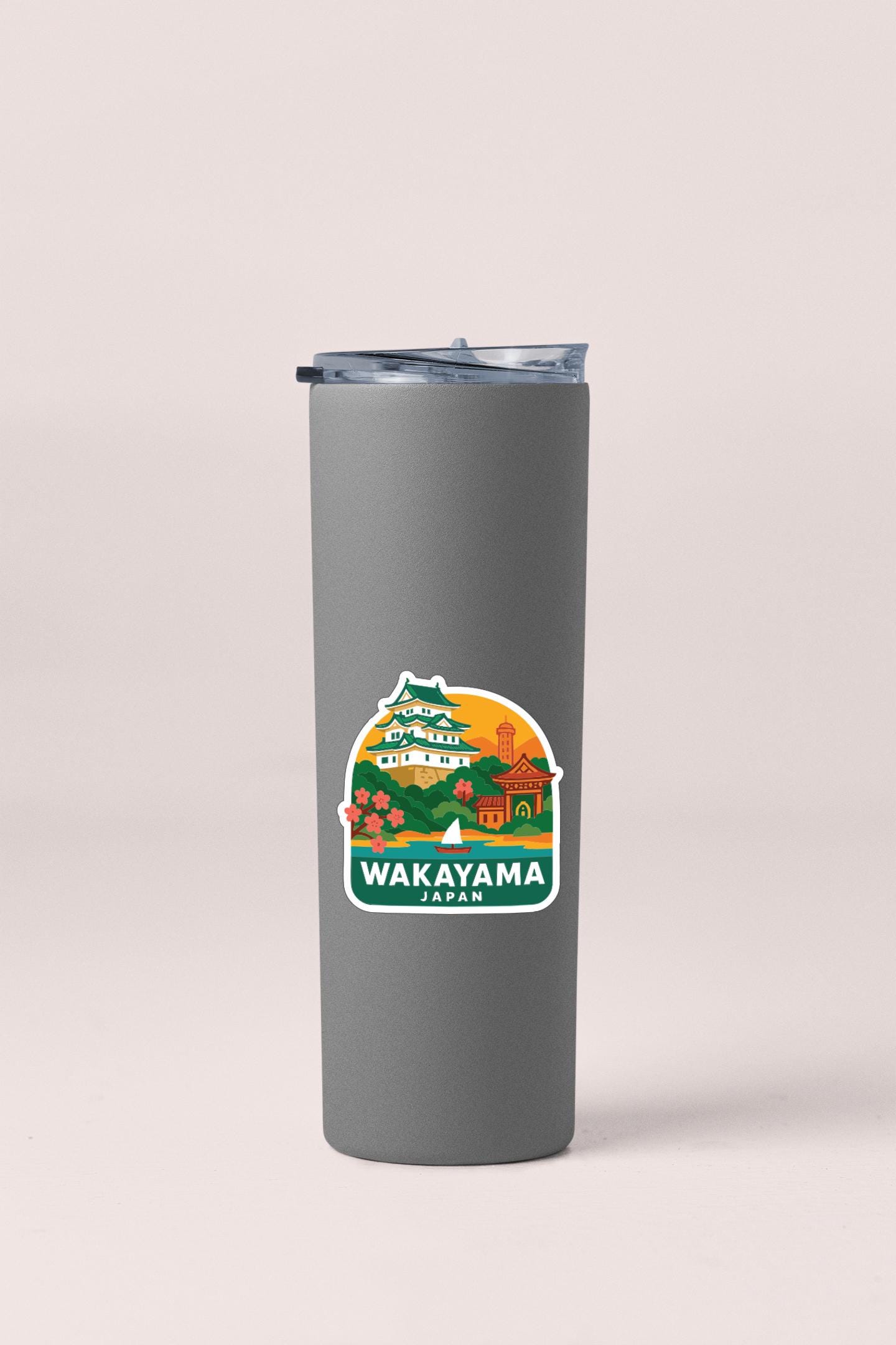 A gray insulated tumbler with a sticker depicting a scenic view of the city of Wakayama, Japan.