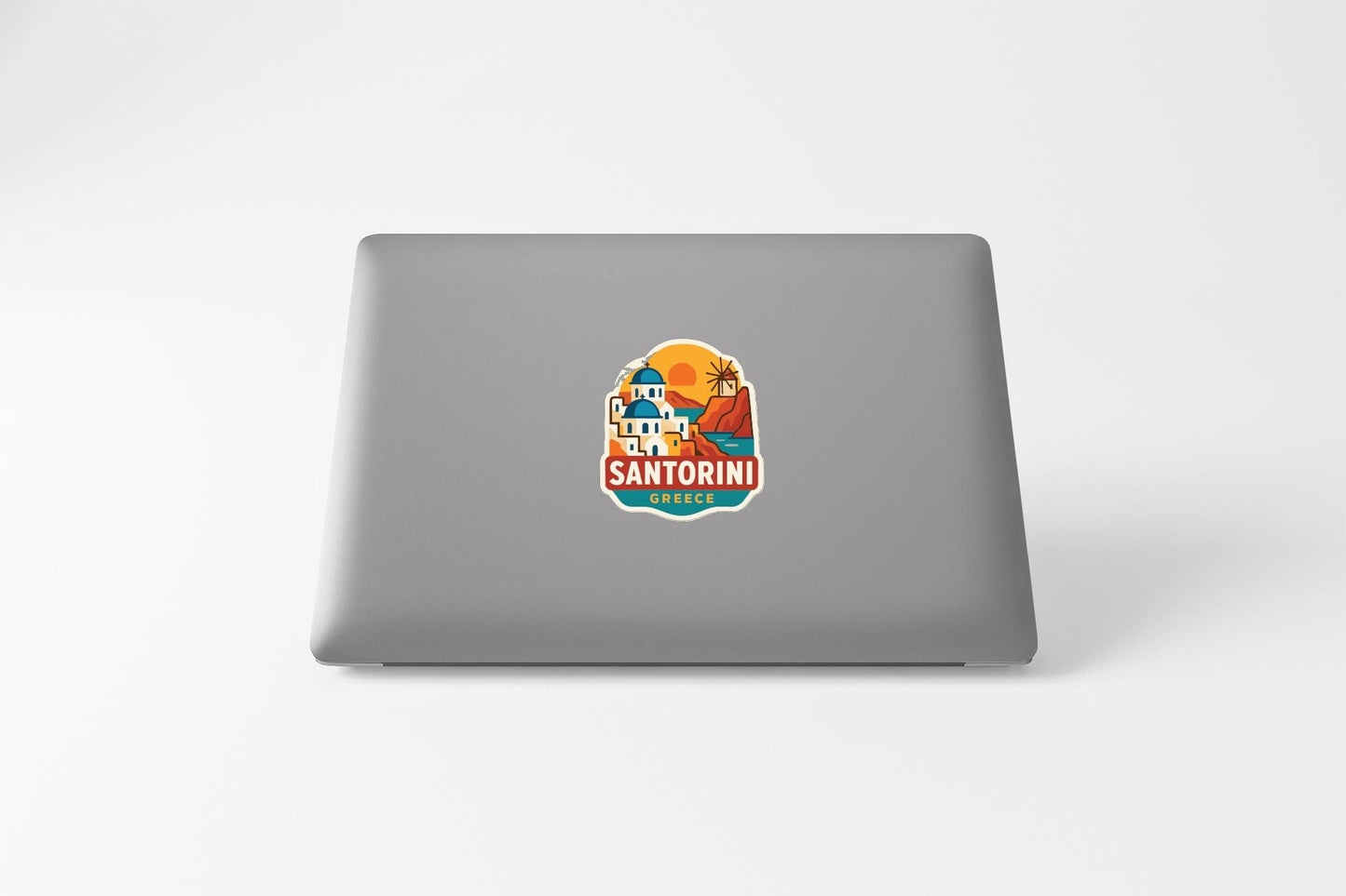 a sticker with a graphic of a building and the text "SANTORIN" on a laptop.