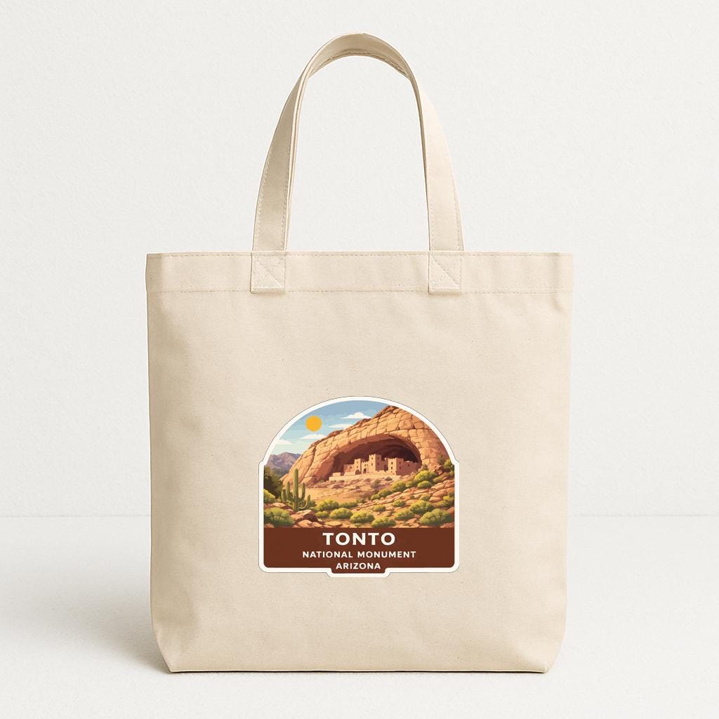 A beige tote bag with a label that features an illustration of the iconic rock formation known as the "Tonto National Monument" in Arizona.