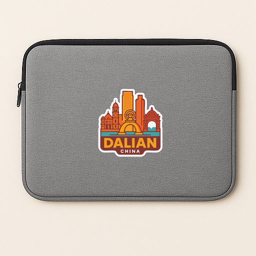 A gray laptop sleeve with a sticker of the city of Dalian, China, printed on it.