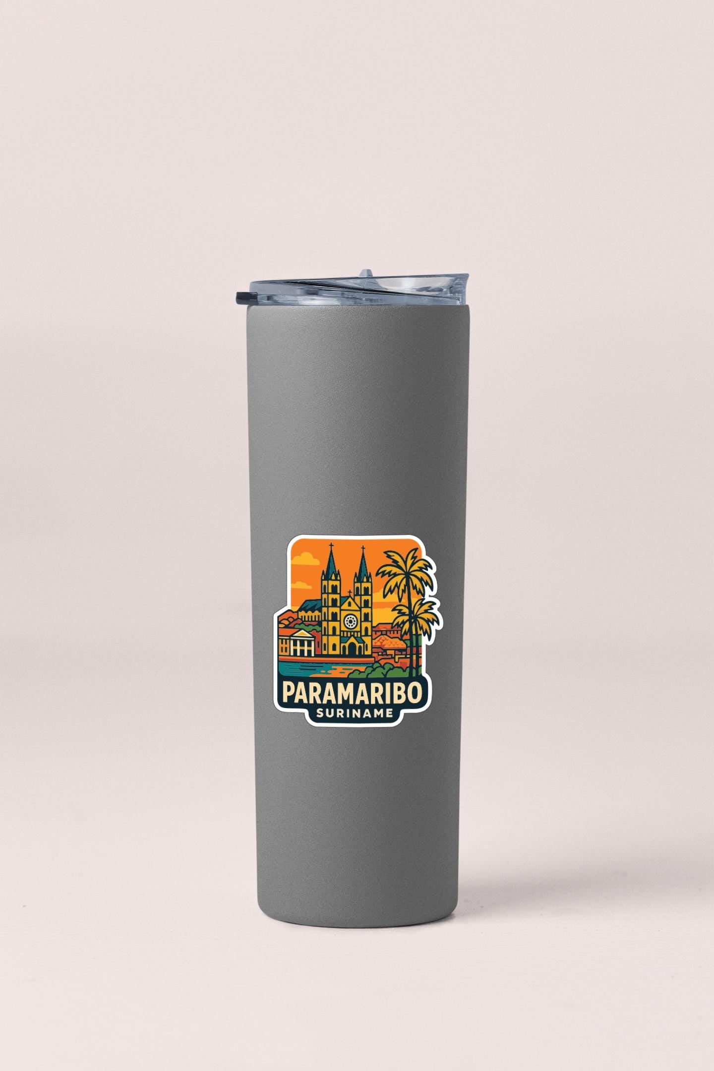A gray insulated tumbler with a sticker depicting a tropical cityscape and the text "PARAMARIO SURRINAME".