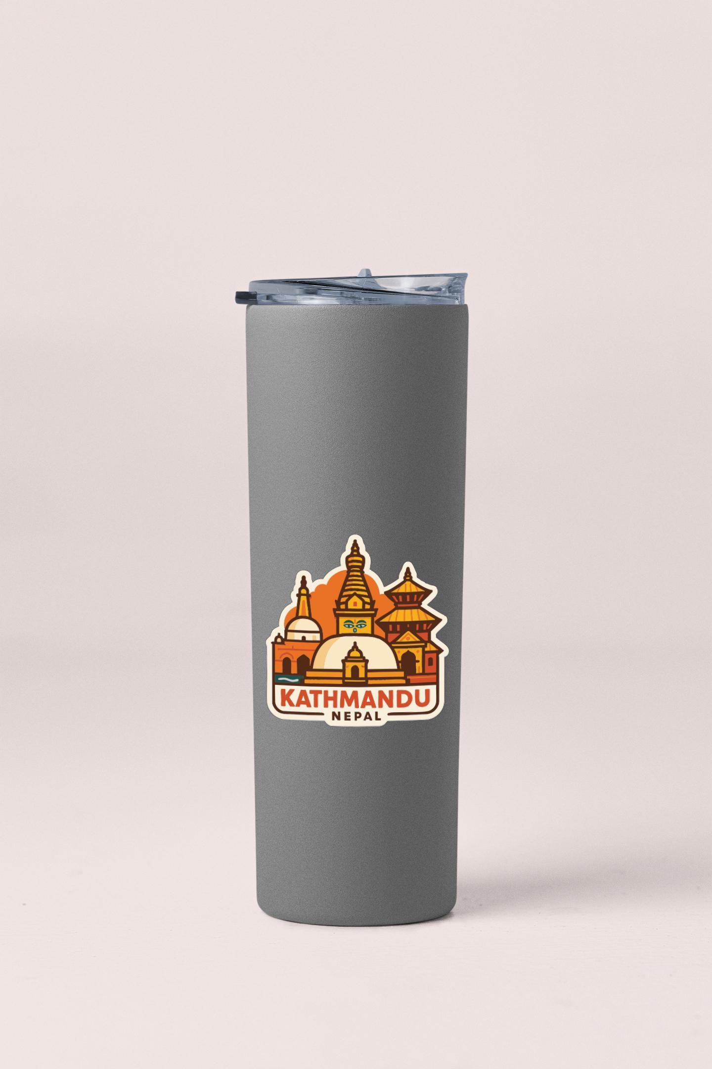 A gray insulated tumbler with a sticker depicting the skyline of Kathmandu, Nepal.