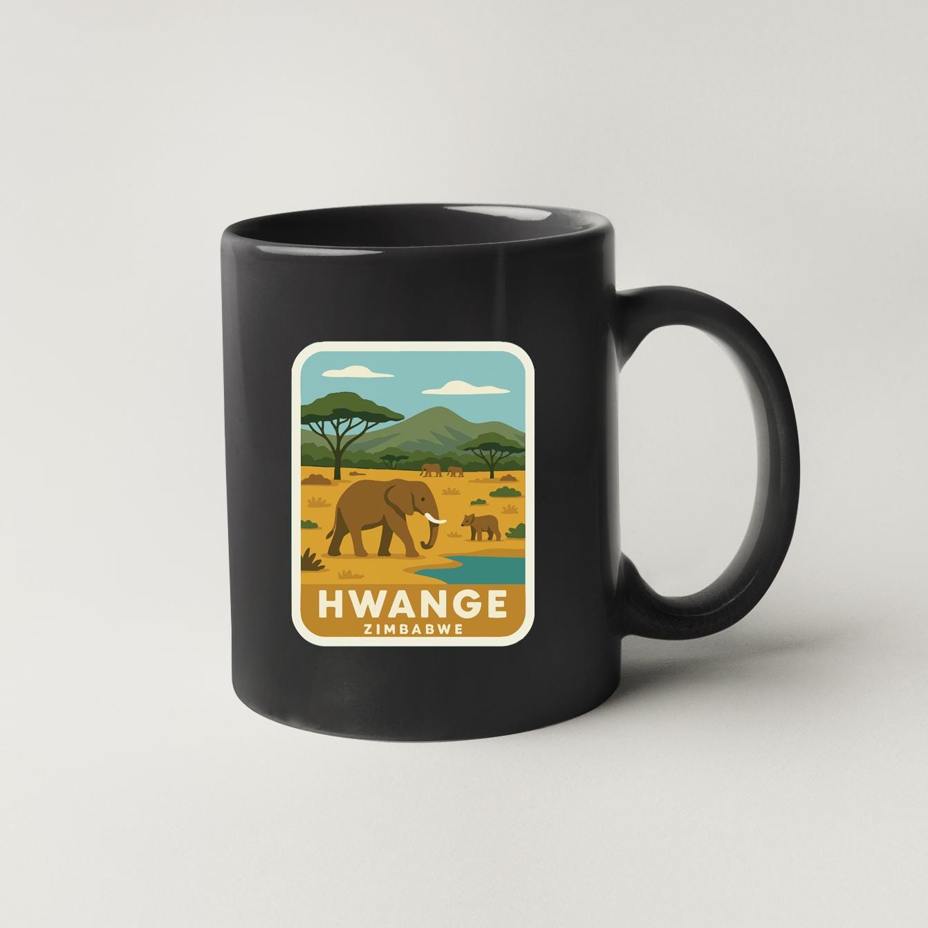 A black coffee mug with a sticker depicting an elephant and a landscape with mountains in Zimbabwe.