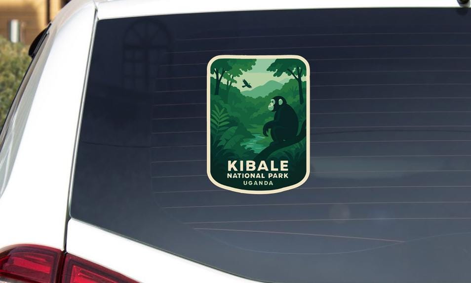 A sticker on the rear window of a car that says "Kibale National Park Uganda".