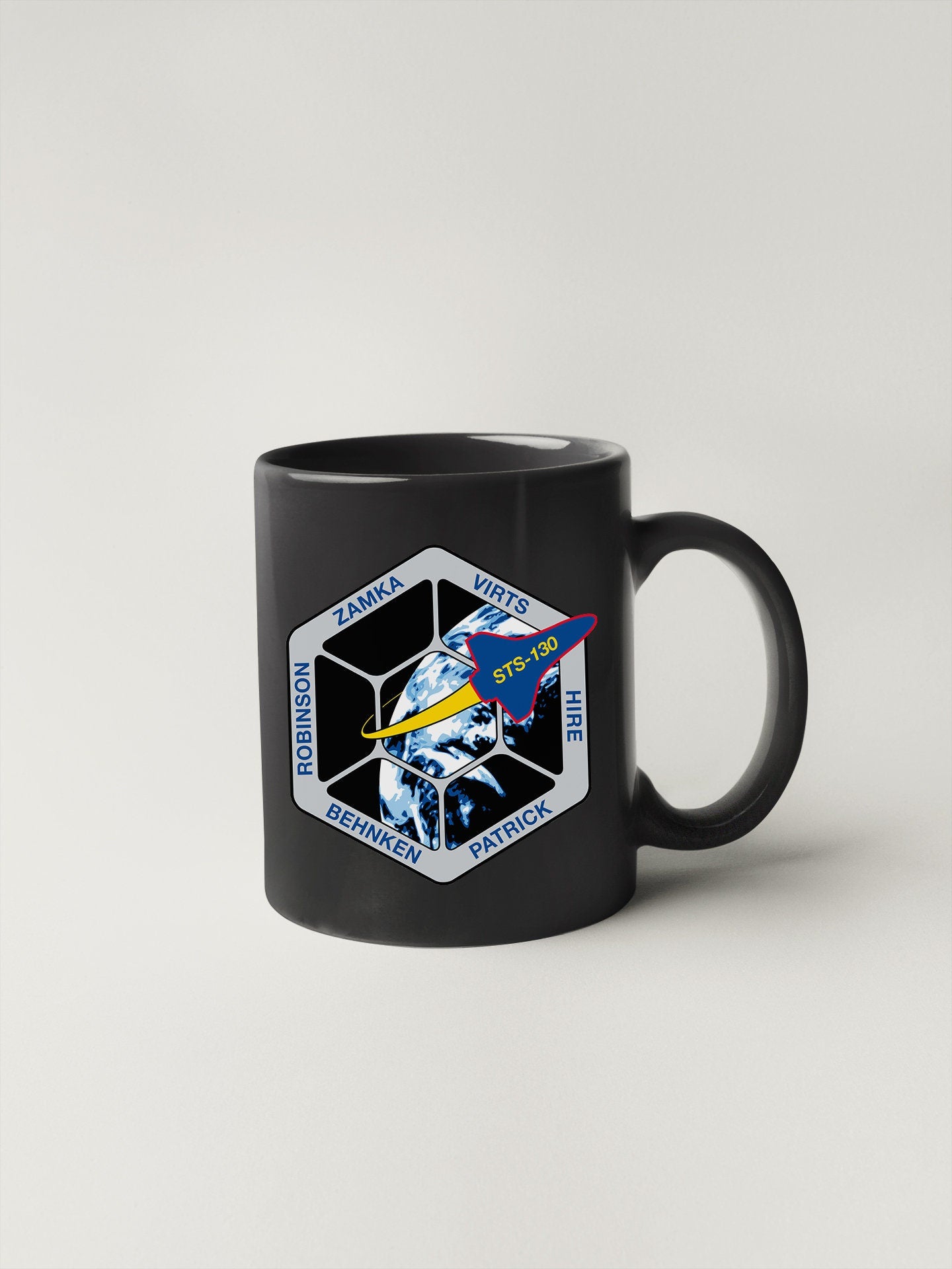 a black coffee mug with a space shuttle on it