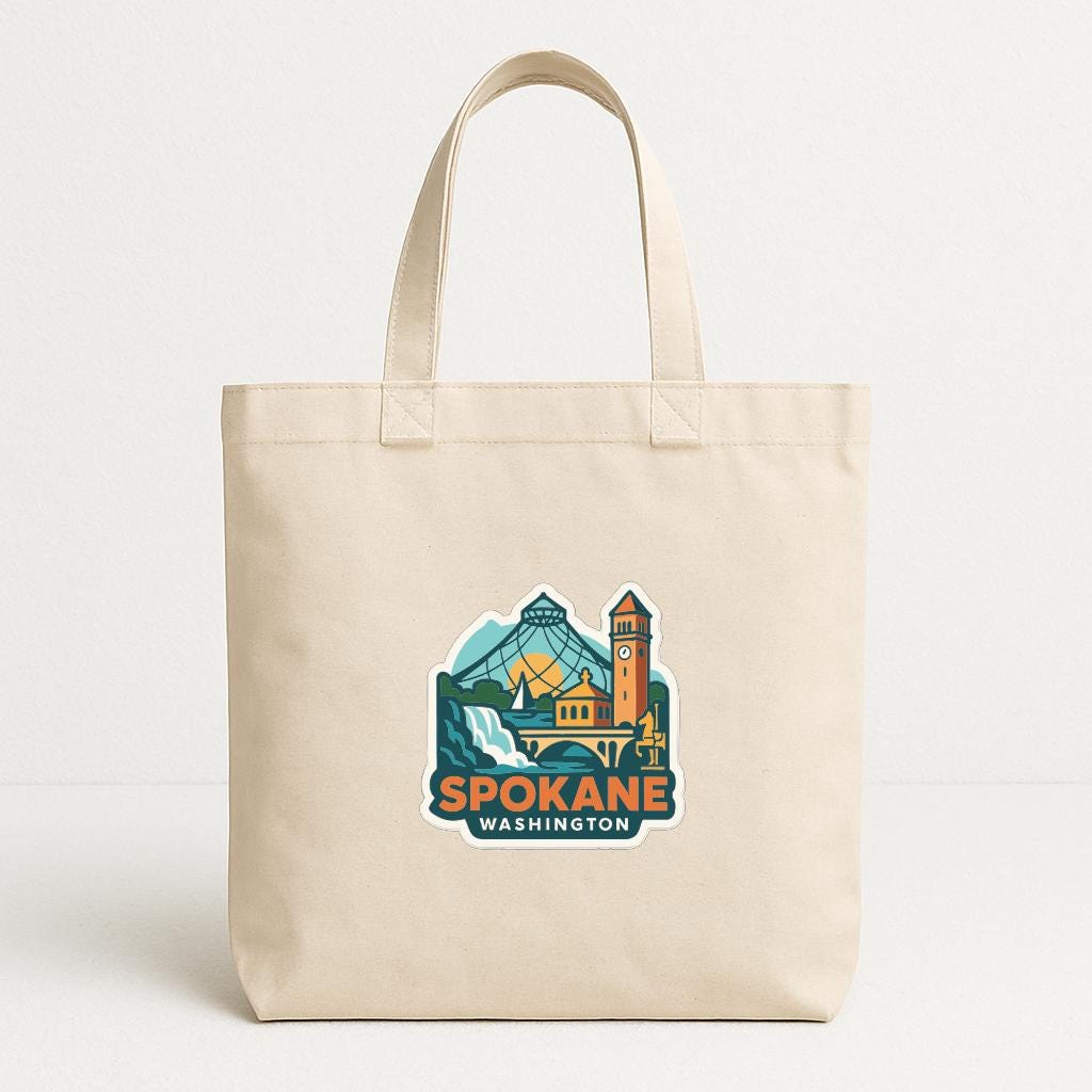 A beige tote bag with a graphic design featuring the city of Spokane, Washington.