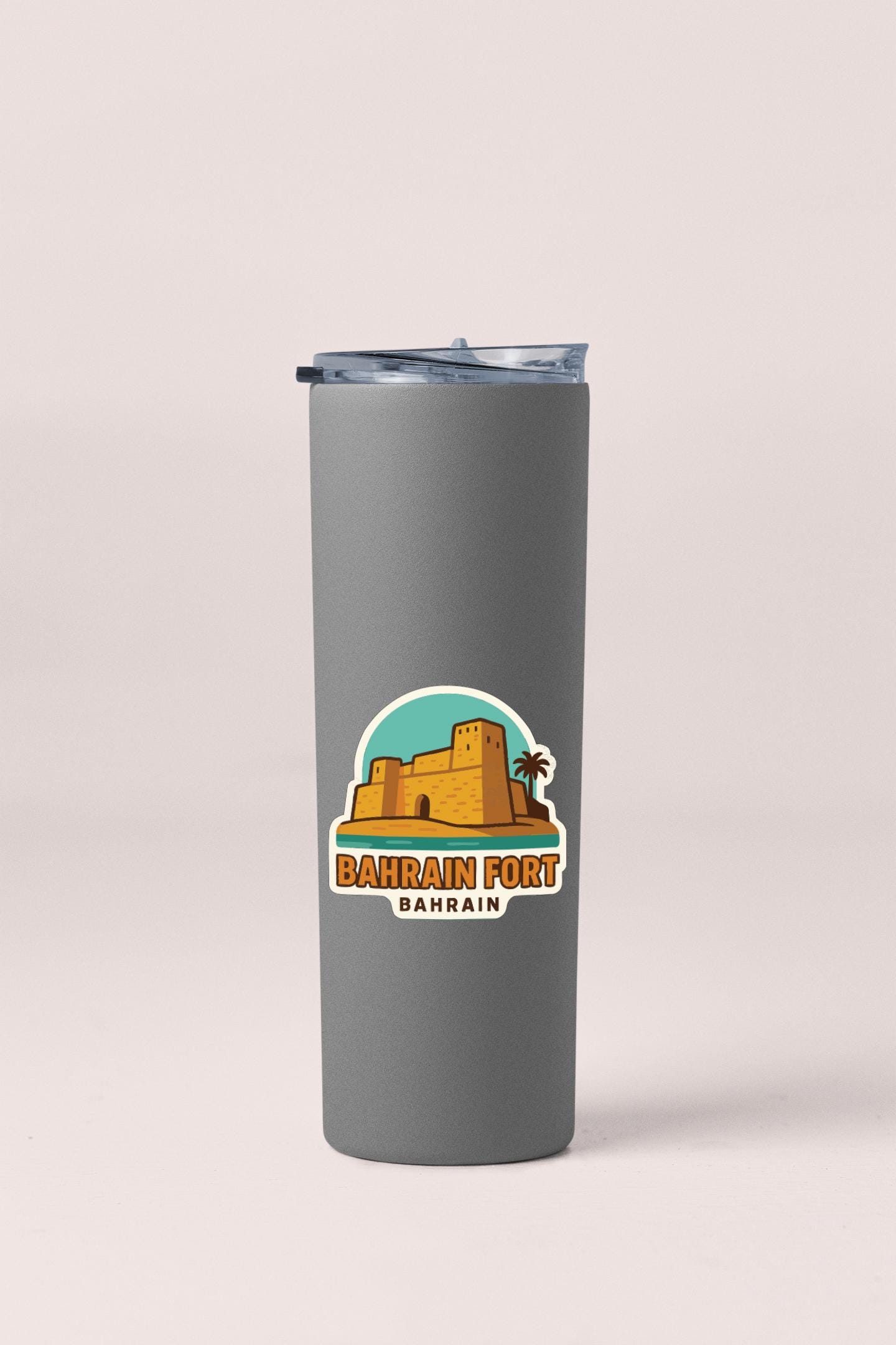 A gray insulated tumbler with a sticker depicting the Bahrain Fort in Bahrain.