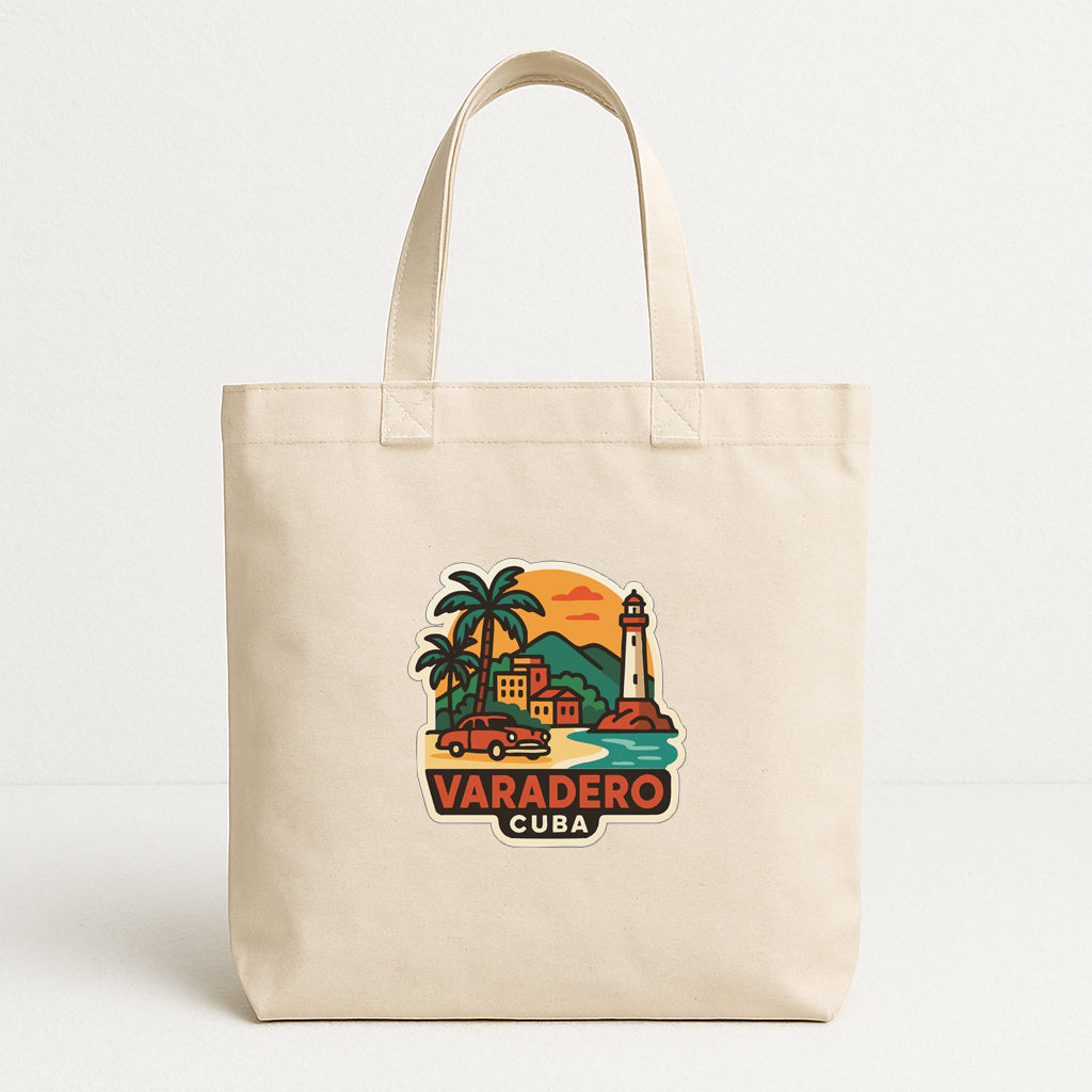 A beige tote bag with a colorful graphic depicting a tropical island scene, including a lighthouse, palm trees, and a car.