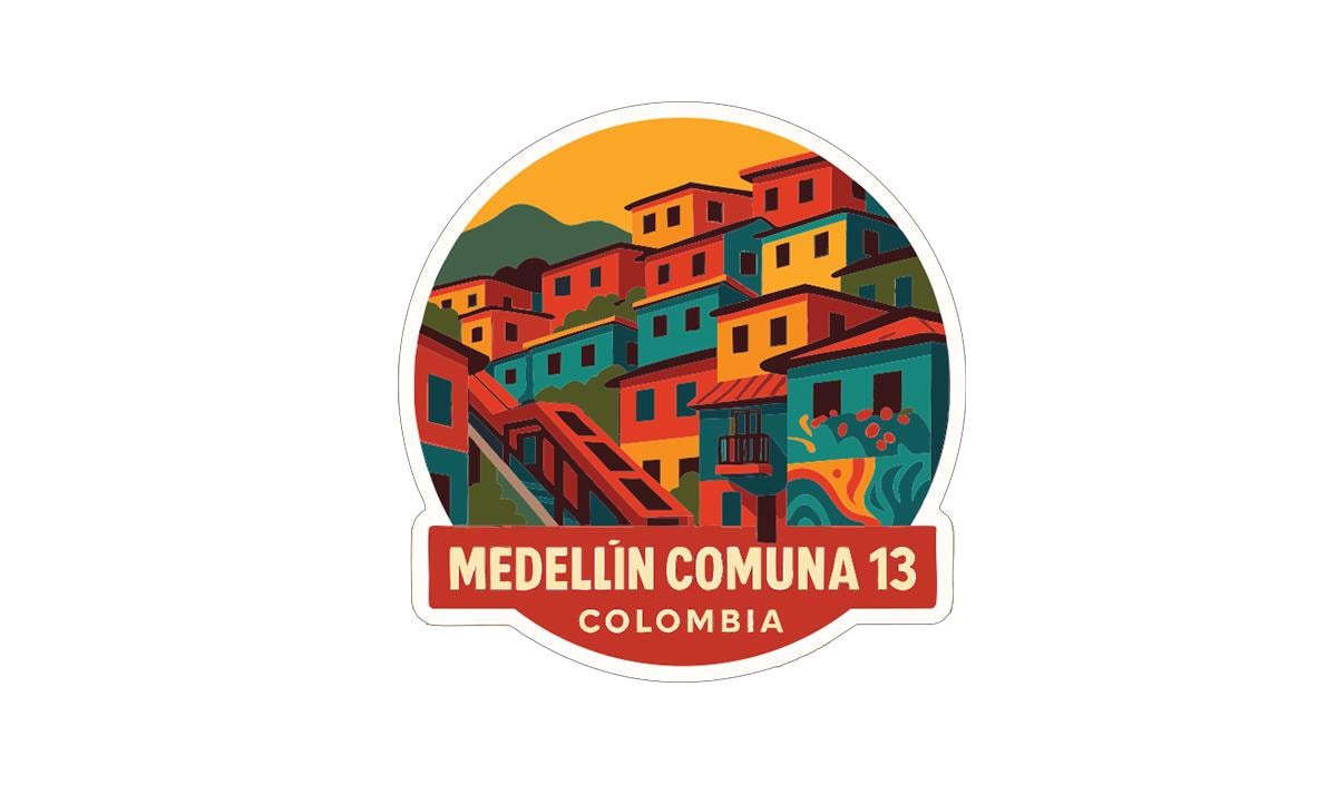 The image is a sticker or emblem featuring a colorful illustration of a town or village, with buildings in various shades of orange, yellow, green, and blue. The text "MEDELLÍN COMÁN 13 COLOMBIA" is prominently displayed, indicating the location of the town or village.