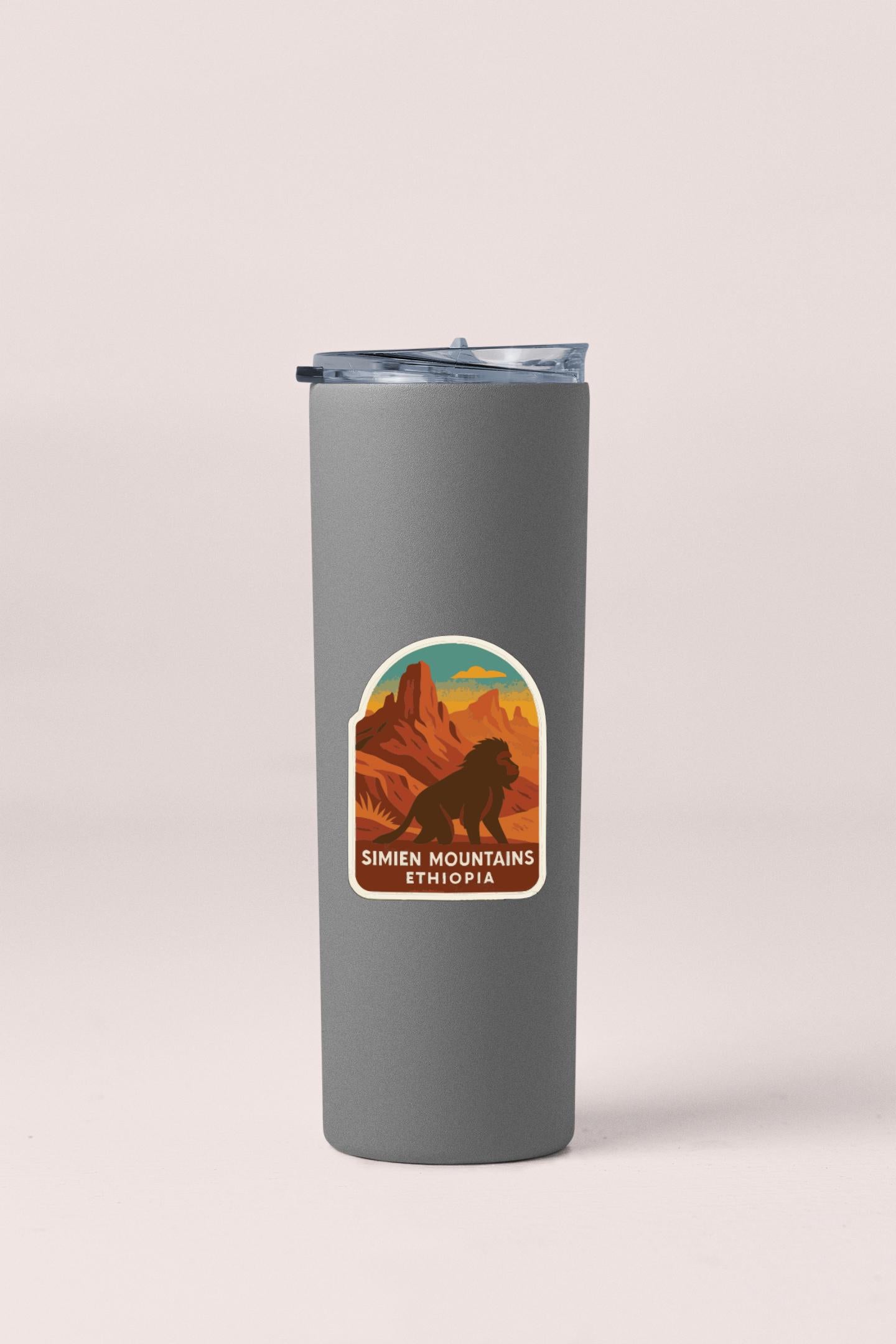 A gray insulated tumbler with a sticker depicting a mountain landscape and the text "SIMIEN MOUNTAINS Ethiopia".