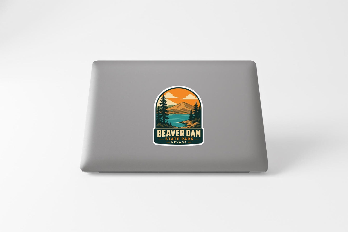 a sticker with a landscape scene and the text "BEAVER DAM BEAVER PARK" printed on a laptop.