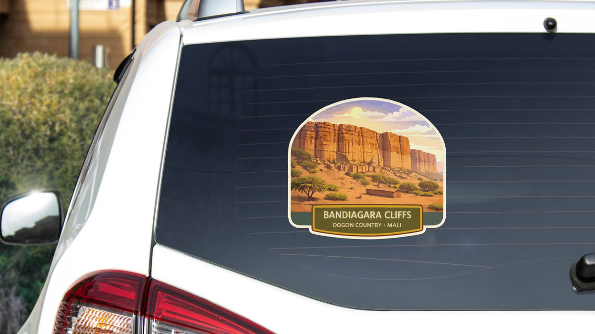a sticker on the rear window of a car, depicting a desert landscape with sand dunes and rock formations.