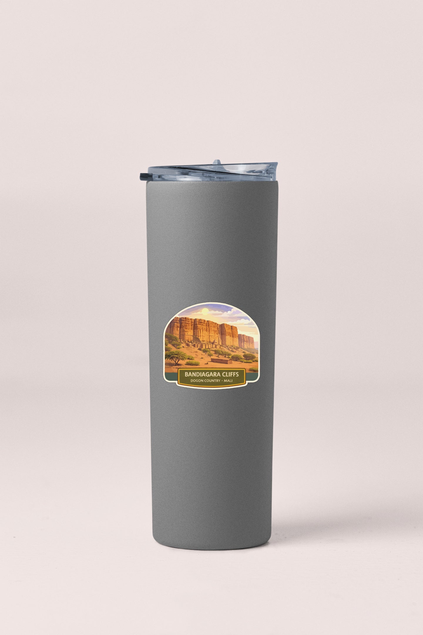 A gray insulated tumbler with a label featuring a scenic image of the Sandbag Cliffs in the San Gabriel Mountains.