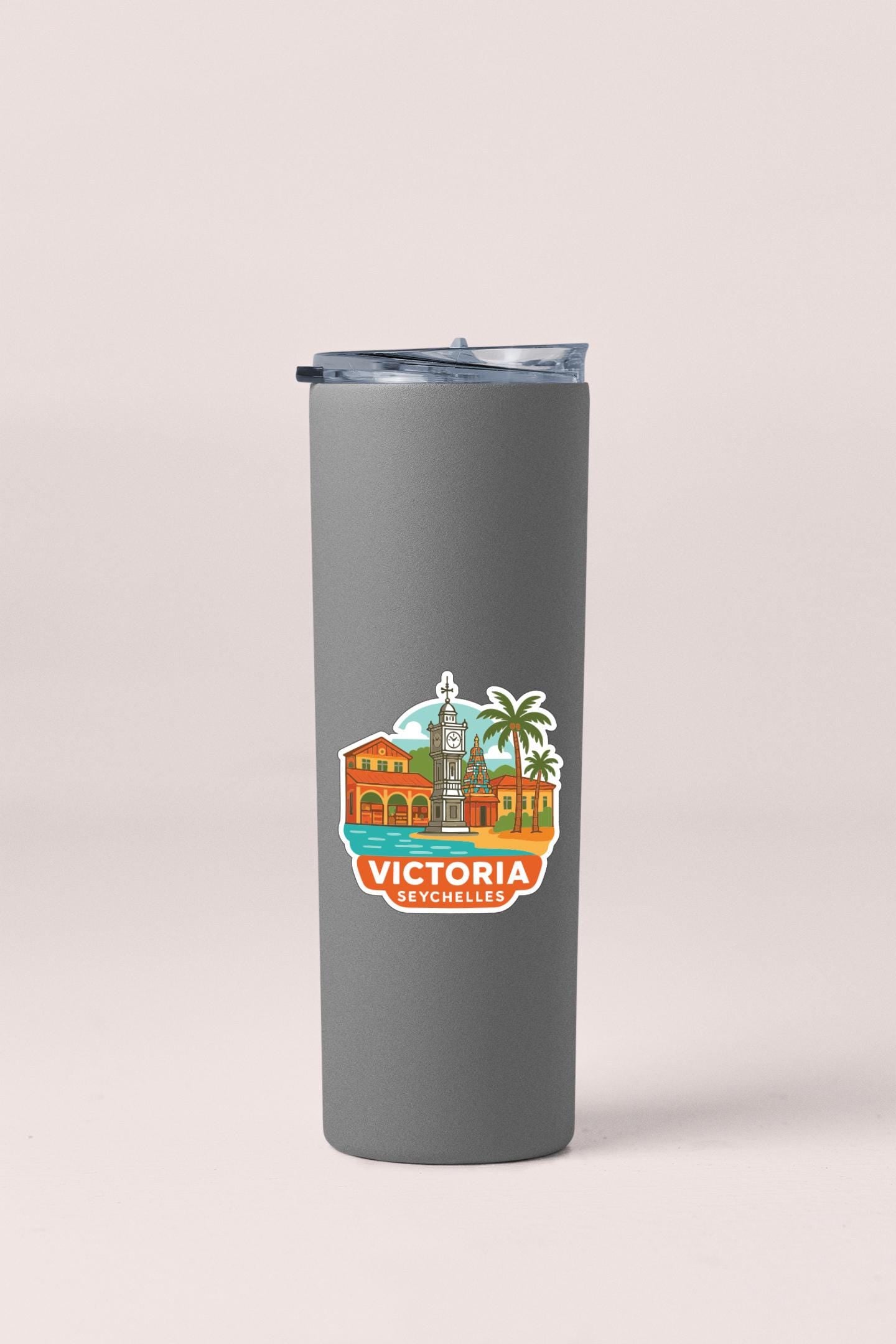 A gray insulated tumbler with a sticker depicting a cityscape and the text "VICTORIA" printed on it.