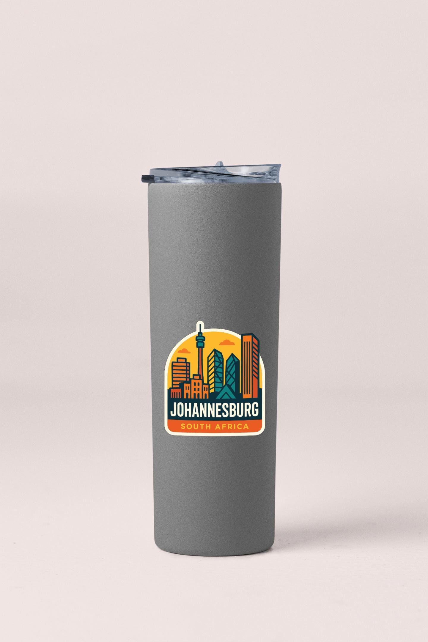 A gray insulated tumbler with a sticker depicting the city of Johannesburg, South Africa.