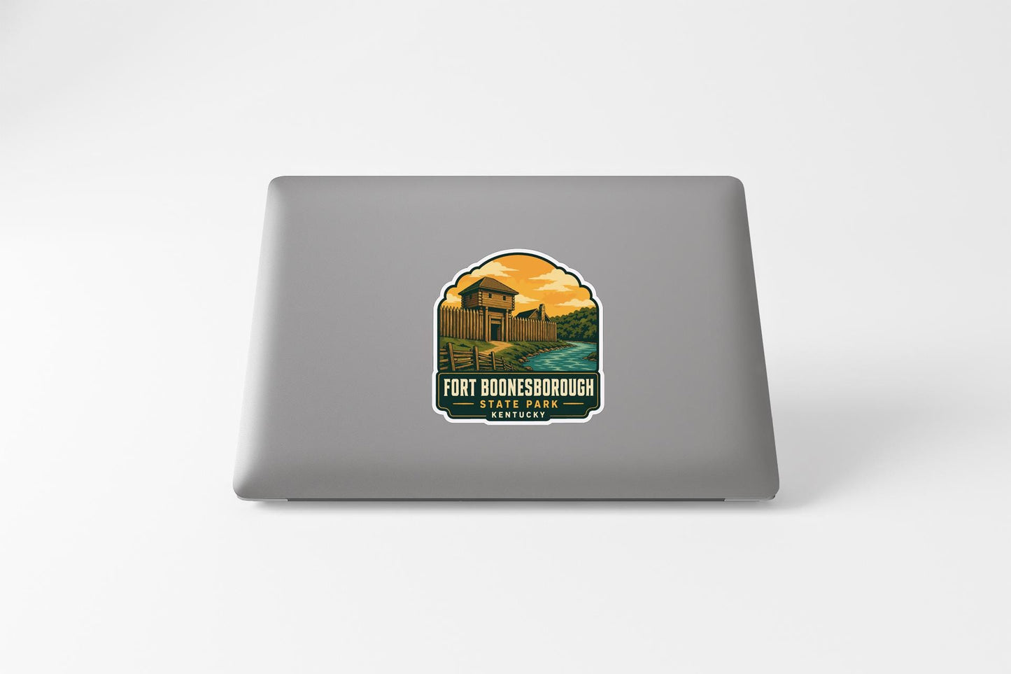 a sticker on the back of a laptop, depicting a scenic landscape with a building and a river.