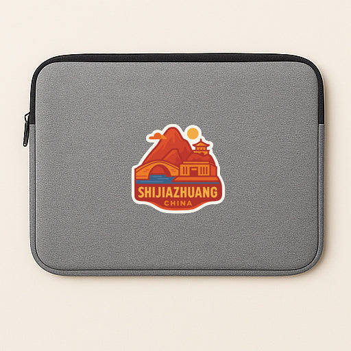 A gray laptop sleeve with a sticker depicting a mountain landscape and the text "SHIJIAZHUANG CHINA".