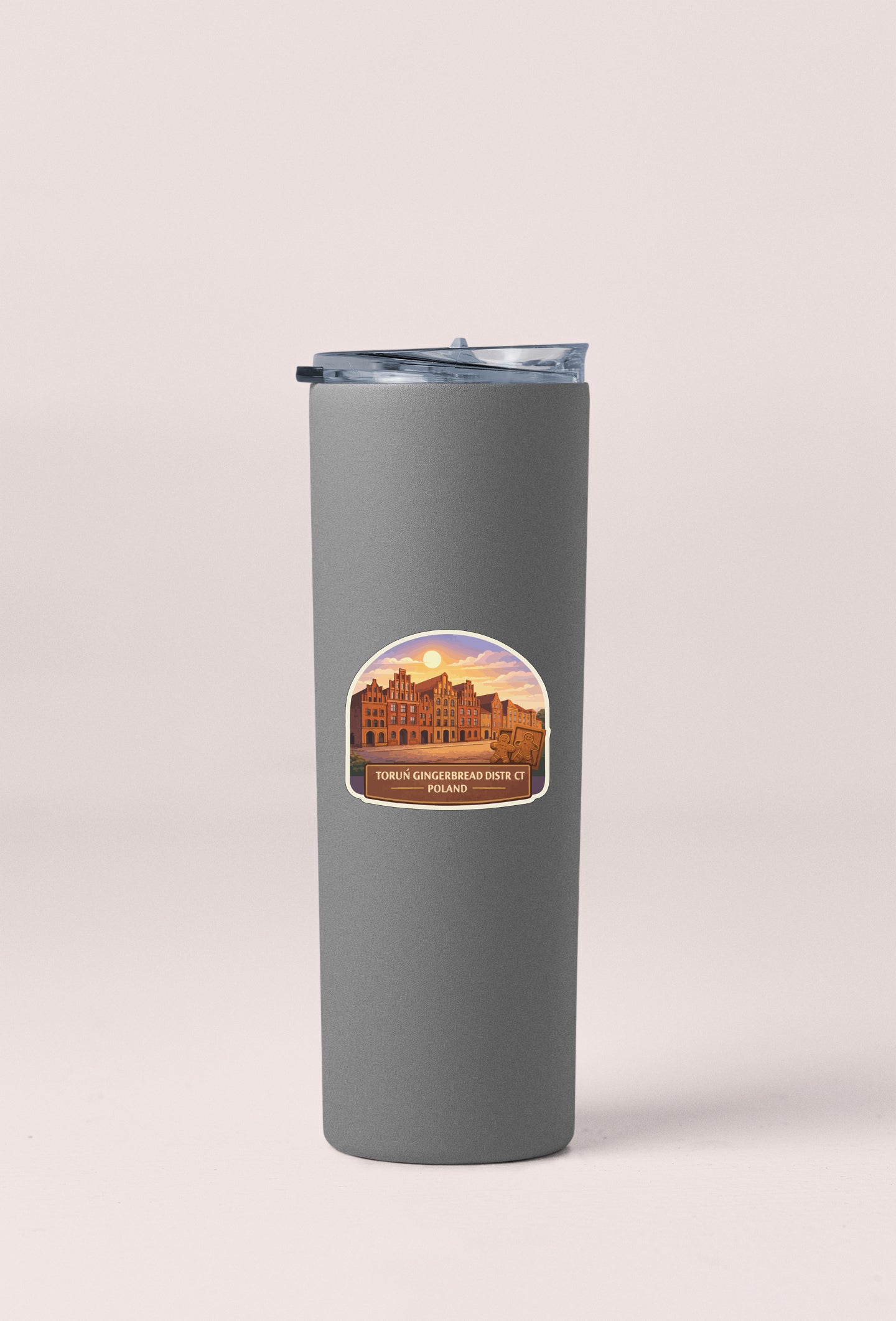 A gray insulated tumbler with a sticker depicting a building and the text "Tornin' gingerbread house das Bier, Poland".