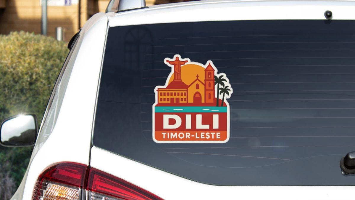 A sticker on the rear window of a car, depicting a tropical city scene with a church, palm trees, and a body of water.