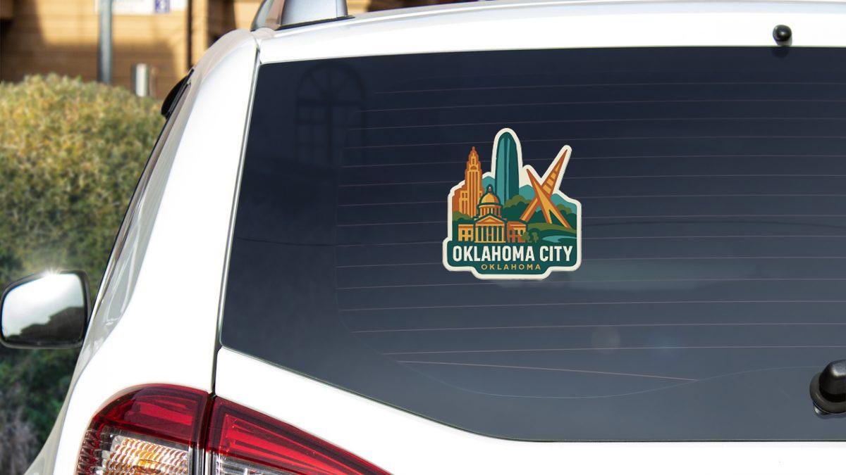 A sticker on the rear window of a white vehicle, depicting the skyline of Oklahoma City, with the text "OKLAHOMA CITY, OK" prominently displayed.