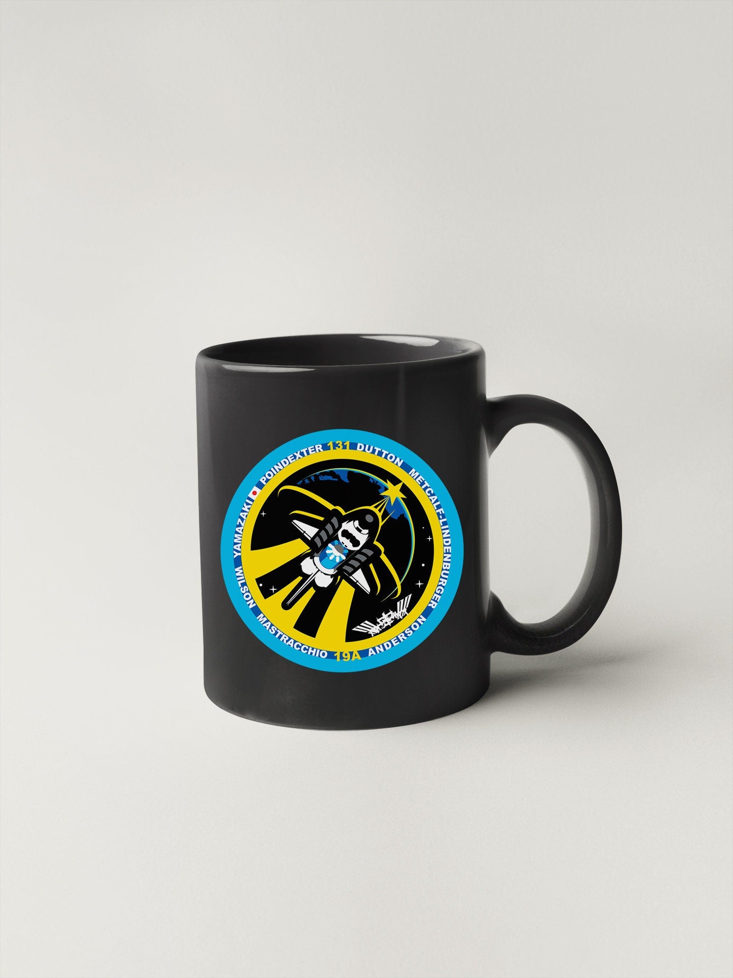a black coffee mug with a blue and yellow design on it