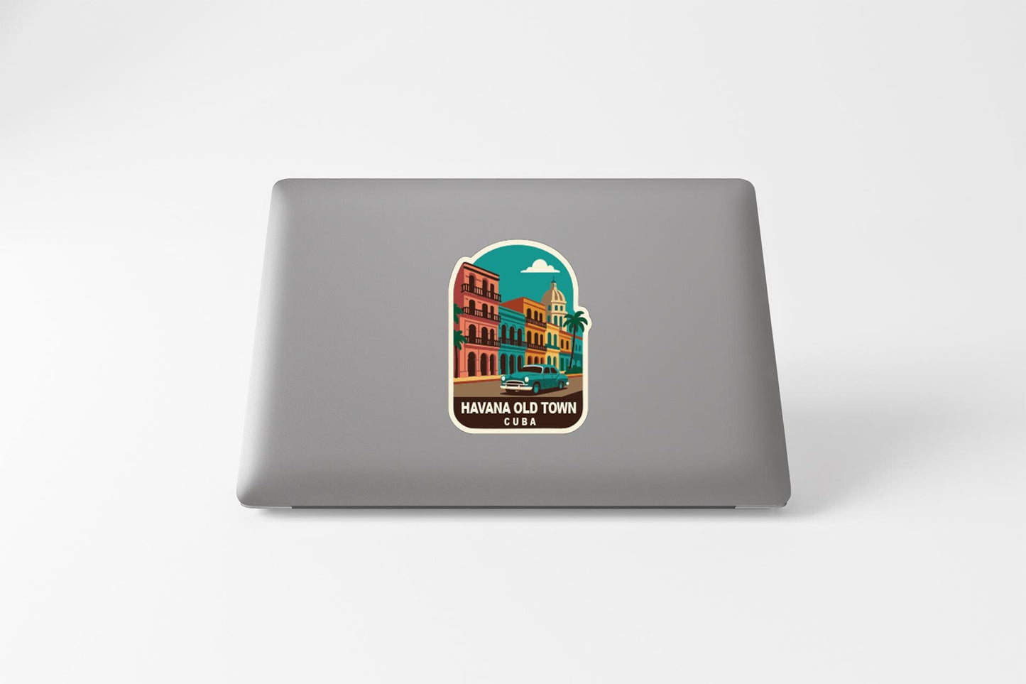 A sticker depicting a colorful illustration of a cityscape with buildings, palm trees, and a car, along with the text "HAWAIIO'OLD TOWN" and "HAWAII" printed on it.