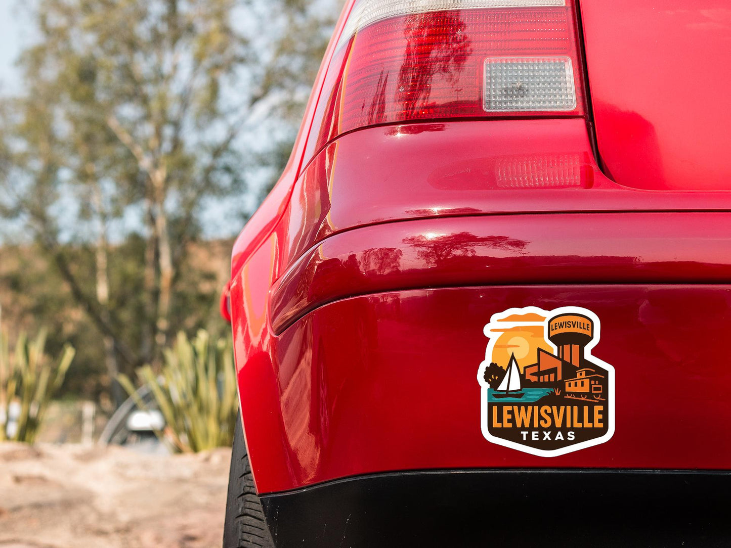 the rear end of a red car with a sticker on the trunk that says "LEWISVILLE TEXAS".