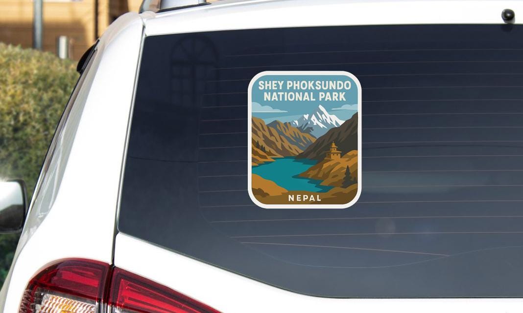 A sticker on the rear window of a car that says "SHEY PHOKSUNDO NATIONAL PARK Nepal".