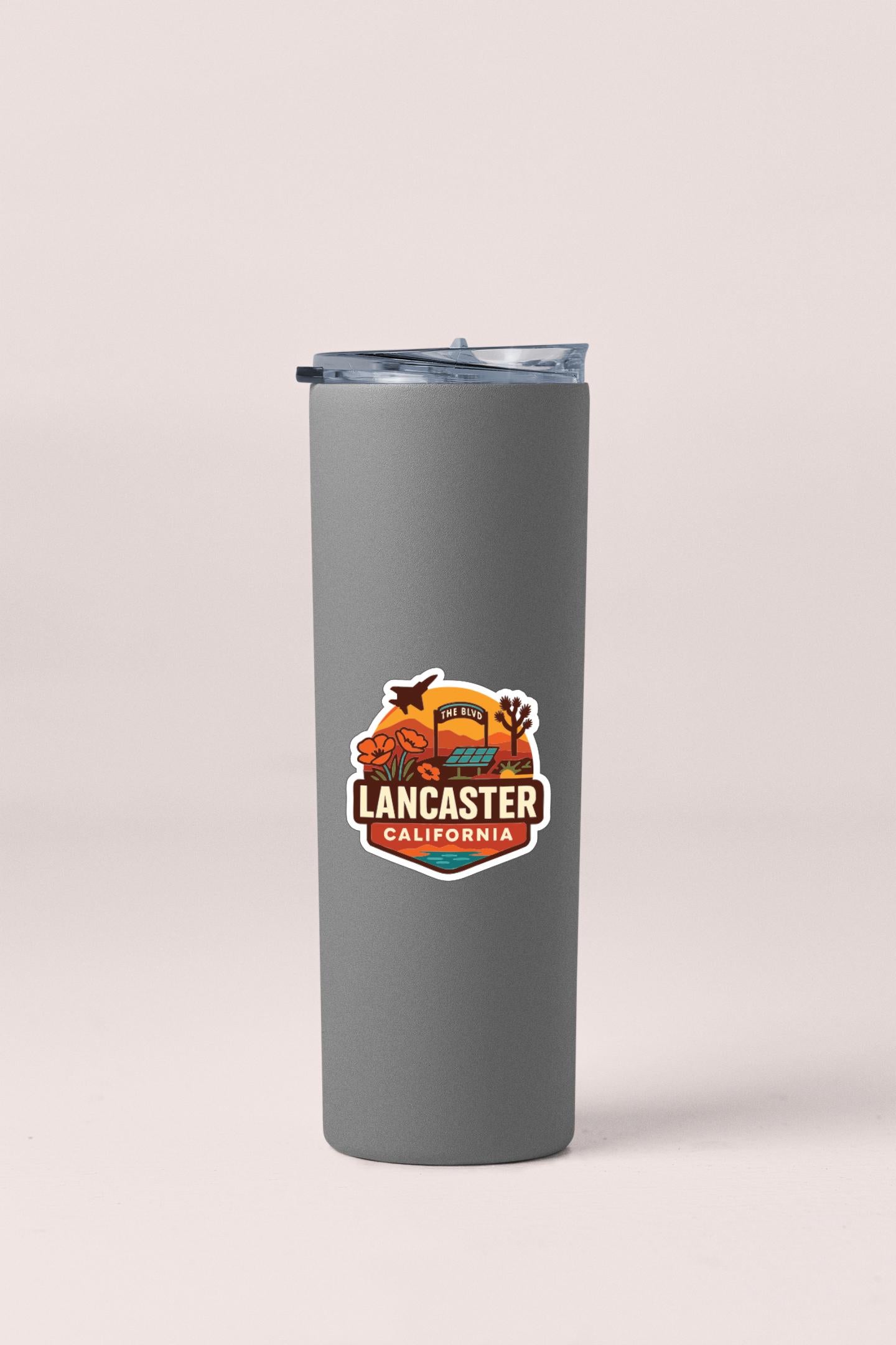 A gray insulated tumbler with a lid and a printed logo that says "LANCASTER CALIFORNIA".