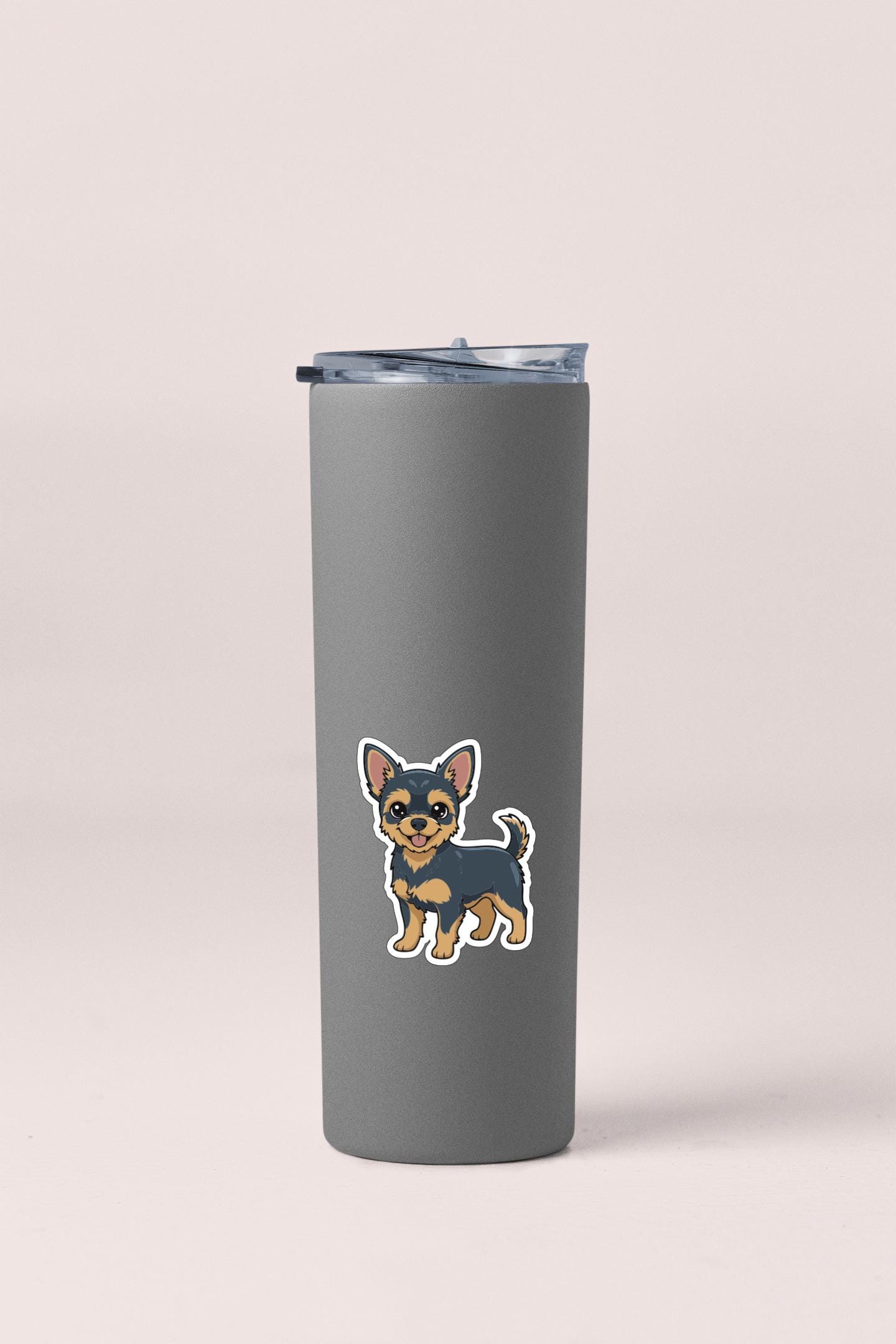 A gray insulated tumbler with a sticker of a small dog on it.