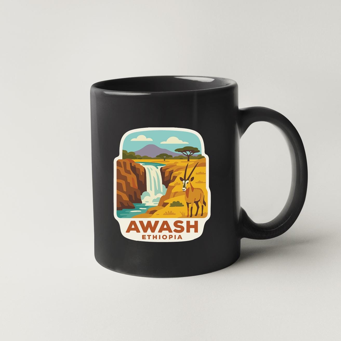 A black coffee mug with a graphic depicting a waterfall and mountains, along with the text "AWASH ETHiopia".