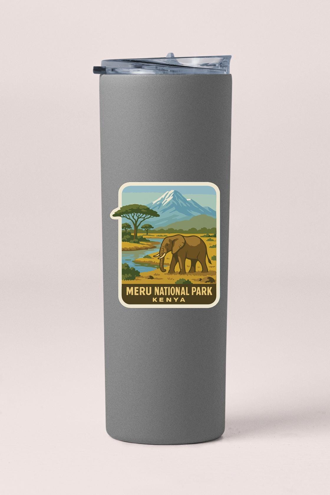 A gray tumbler with a label that features an illustration of an elephant and a mountain landscape, along with the text "MERU NATIONAL PARK KENYA".